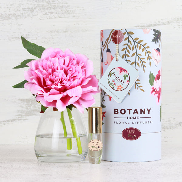 Fake pink peony flower stem in glass vase and gift box packaging