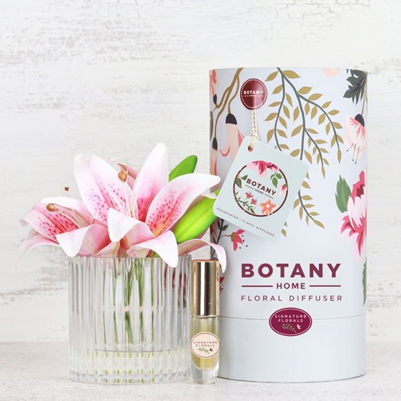 Fake pink lily flowers in vase with perfume spray