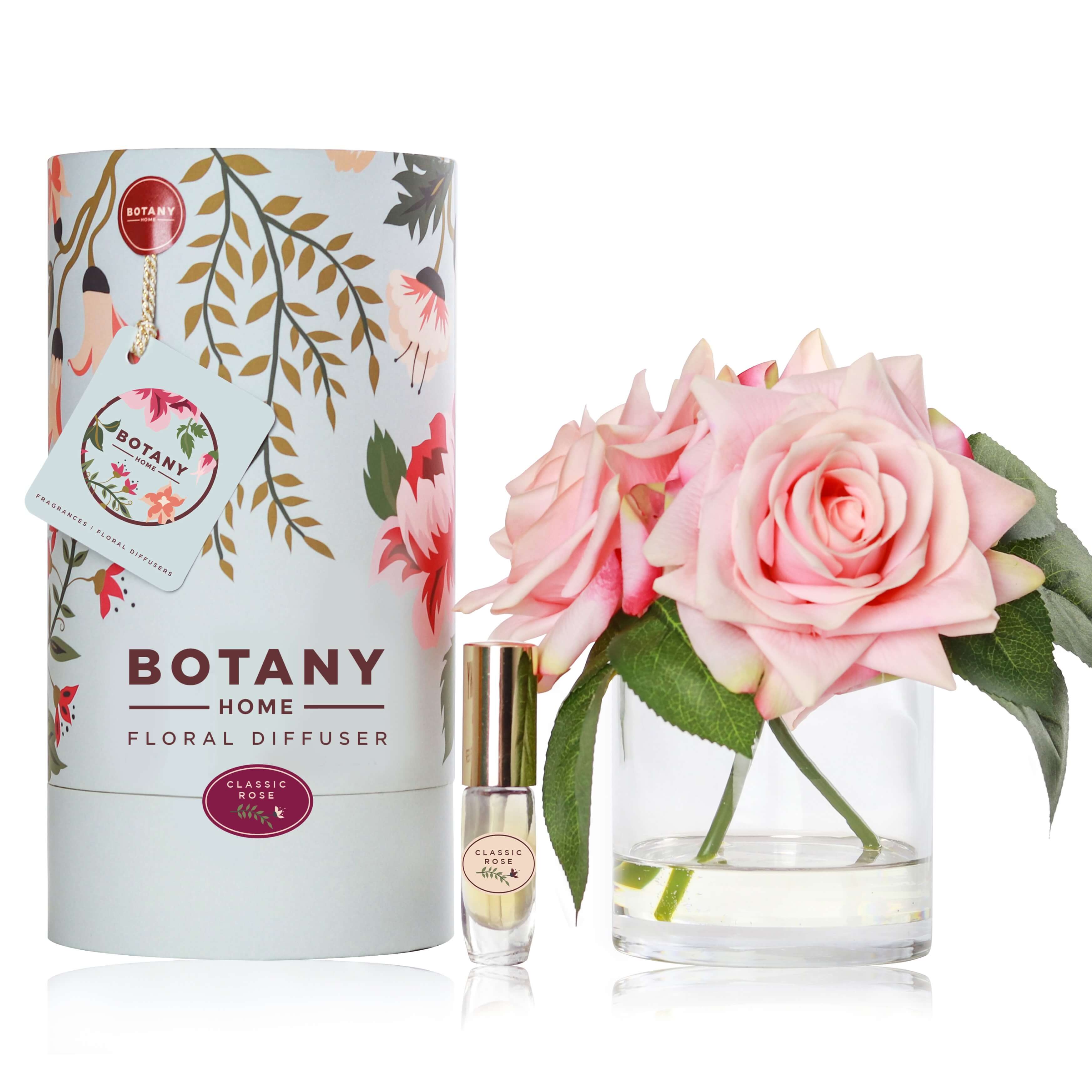 3 artificial pink roses arranged in a glass vase paired with a classic rose fragrance spray