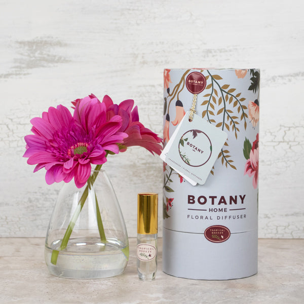 Artificial pink daisy flowers in glass vase