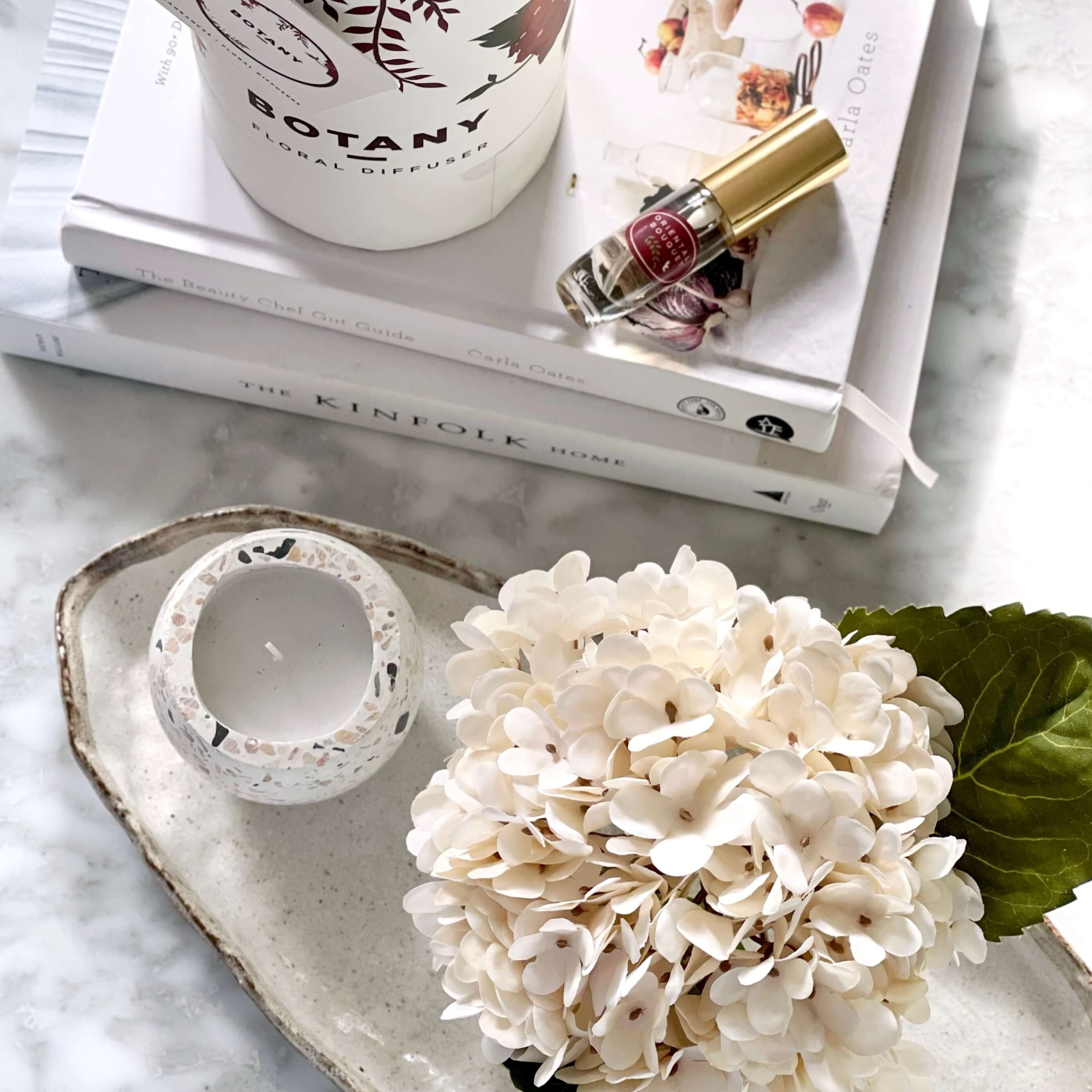 An artificial cream hydrangea flower arrangement paired with a floral scent spray