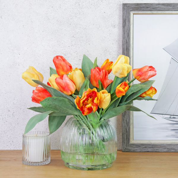 Fake yellow and orange tulip mix in glass vase