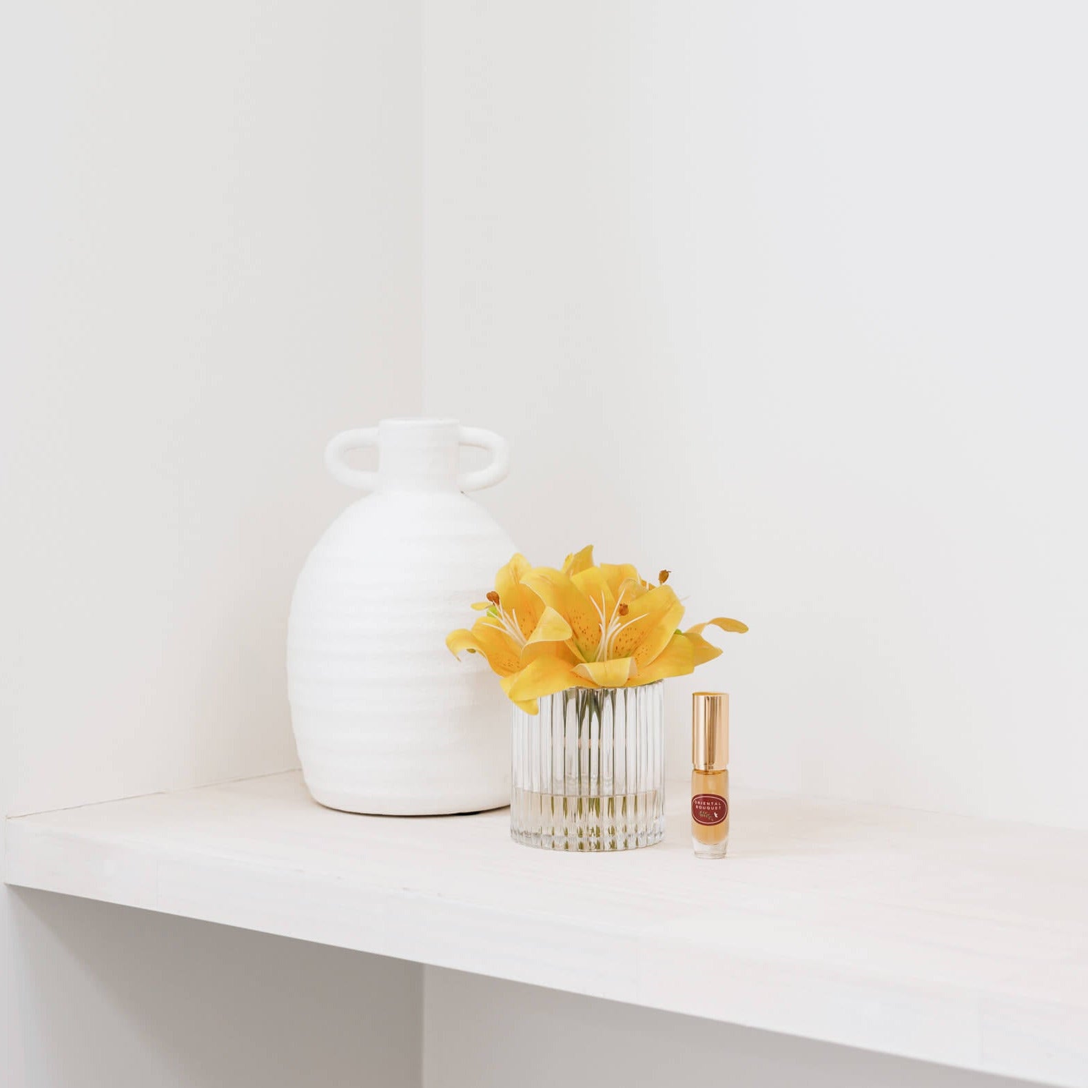 Silk yellow lily flowers in vase with perfume
