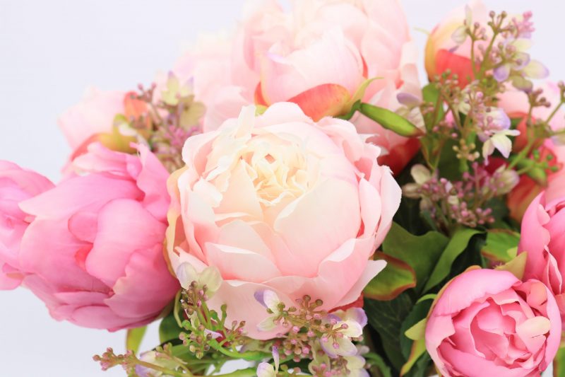 Fake peony flowers in arrangement