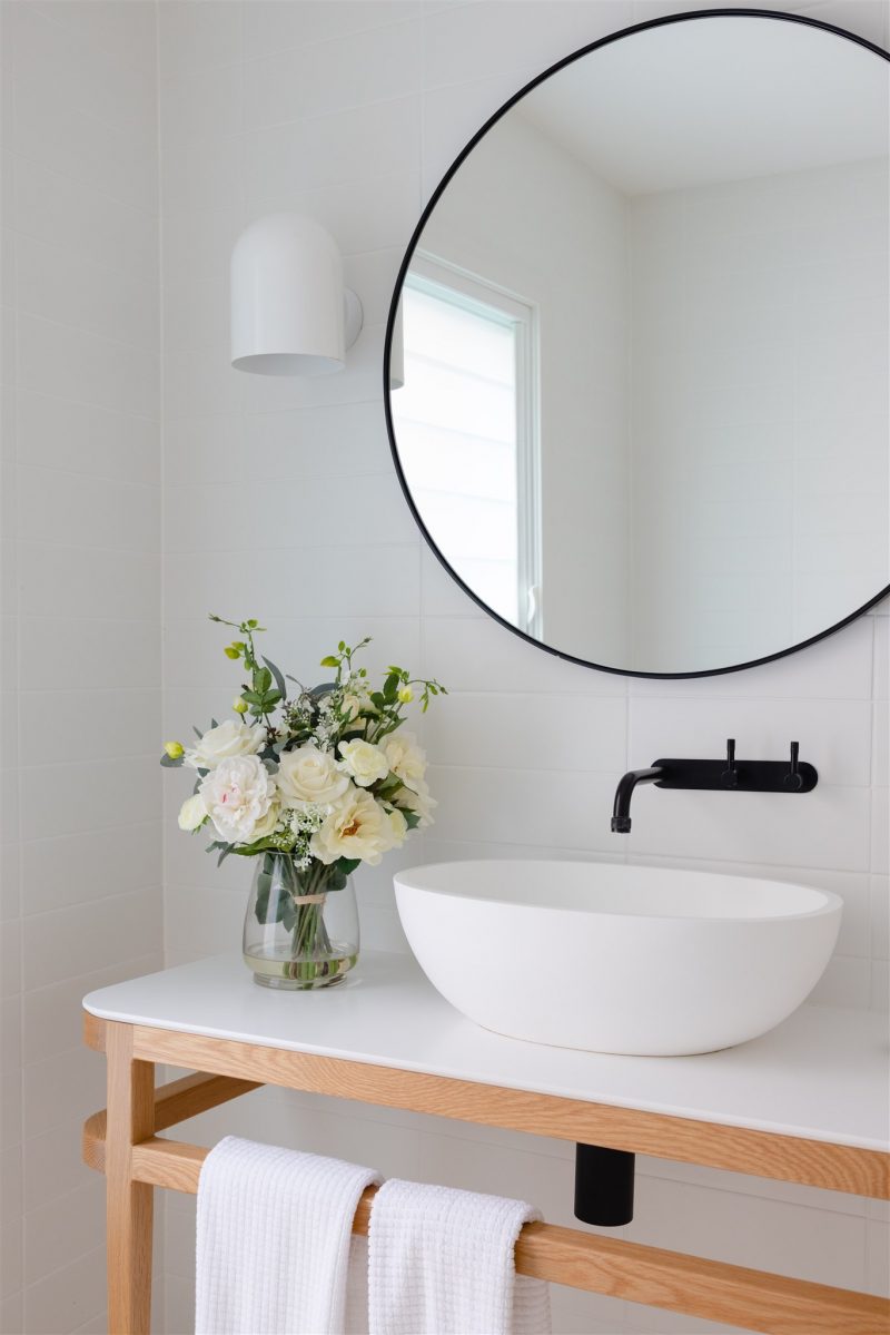 Fake flower bouquet positioned next to bathroom basin