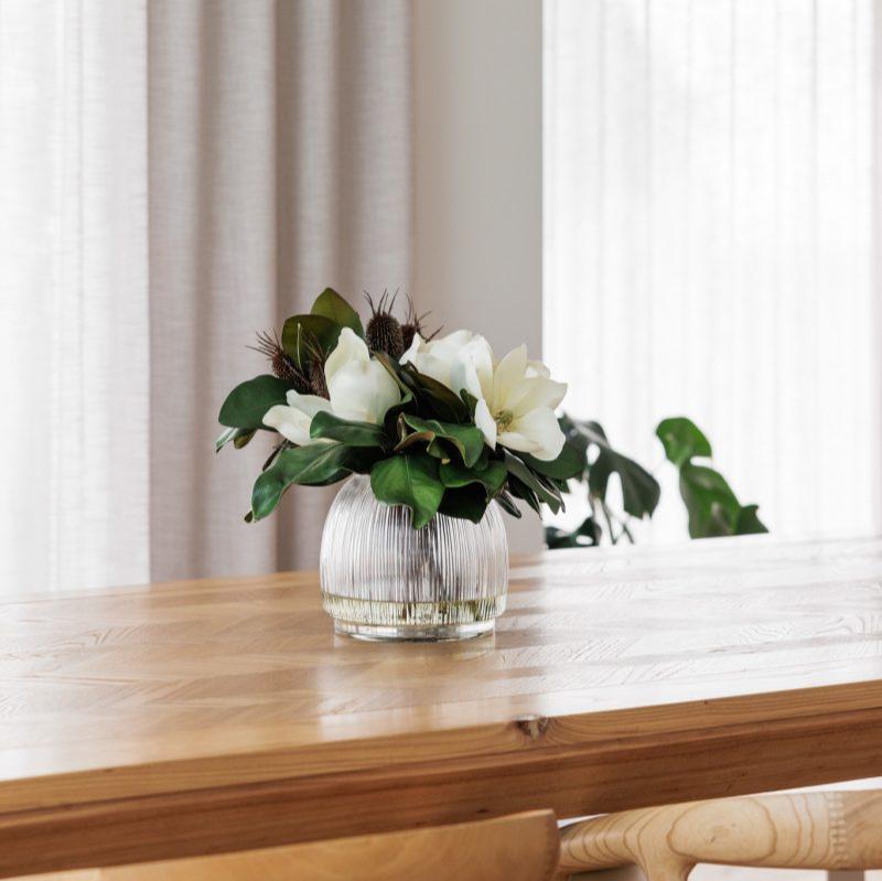 Fake magnolia flower arrangement on a dining table