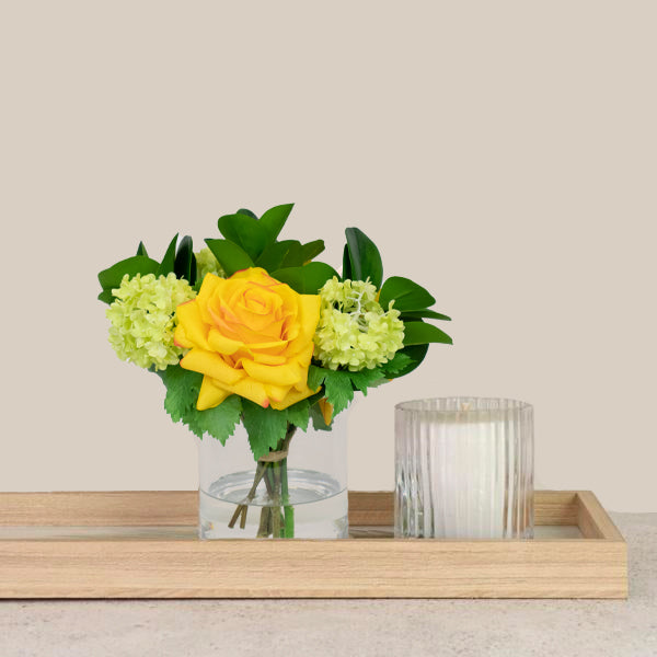 Artificial flowers in glass vase with silk roses