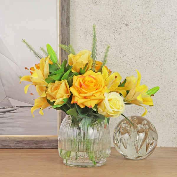 Silk lily and rose flowers in glass vase with resin water