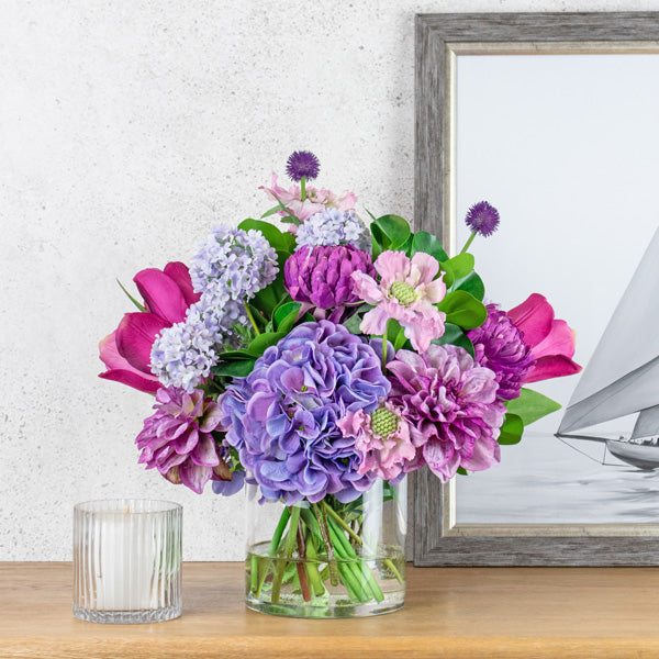 Artificial flower arrangement in glass vase using fake Dahlia flowers