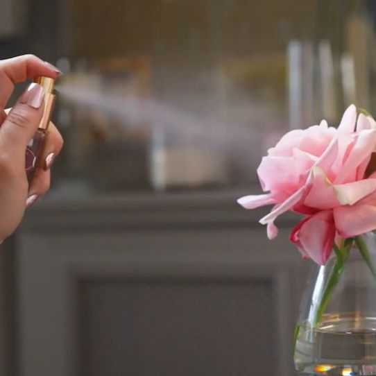 floral perfumed being sprayed onto fake flower