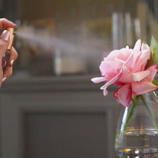 Fake flower being sprayed with perfume