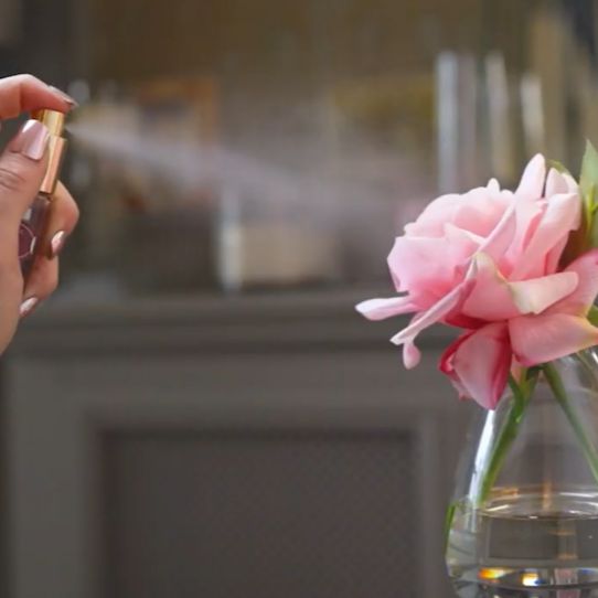 Fake flower being sprayed with perfume