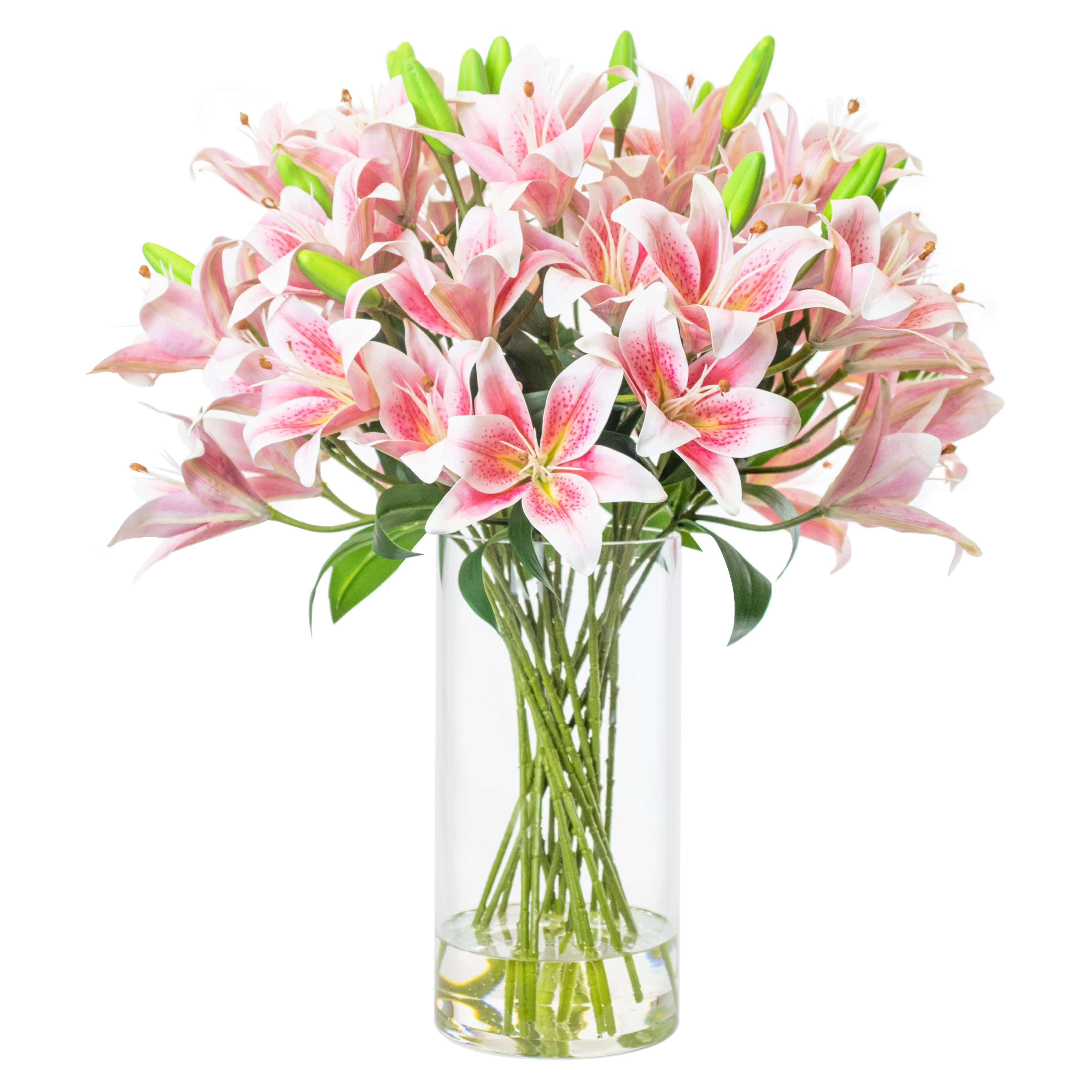 Artificial pink lily arrangement set in tall glass vase