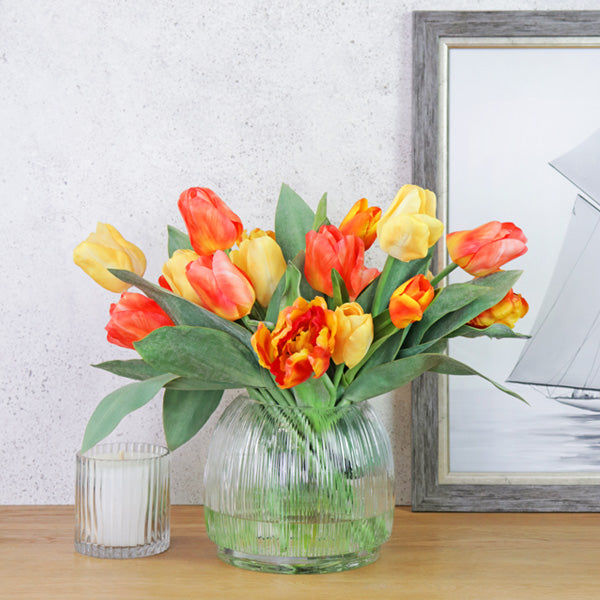 Fake yellow and orange tulip mix in glass vase