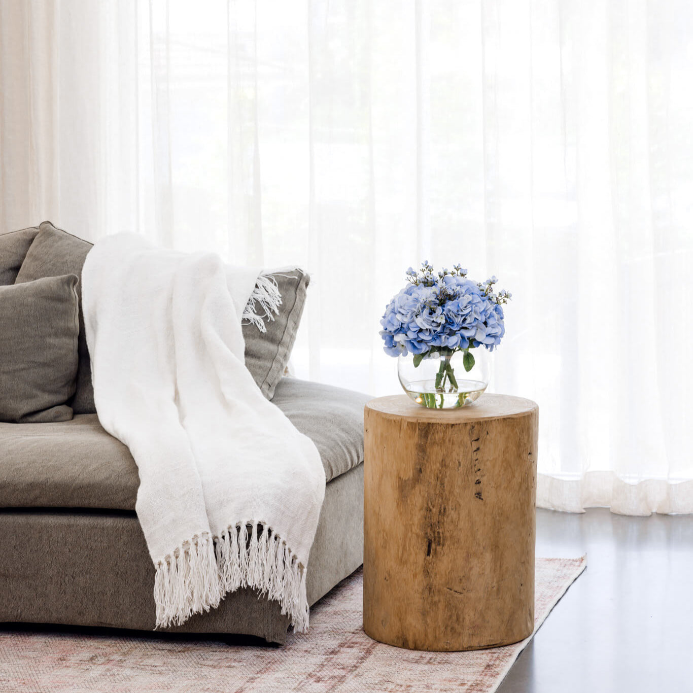 Faux Blue Hydrangea Arrangement on side table next to sofa