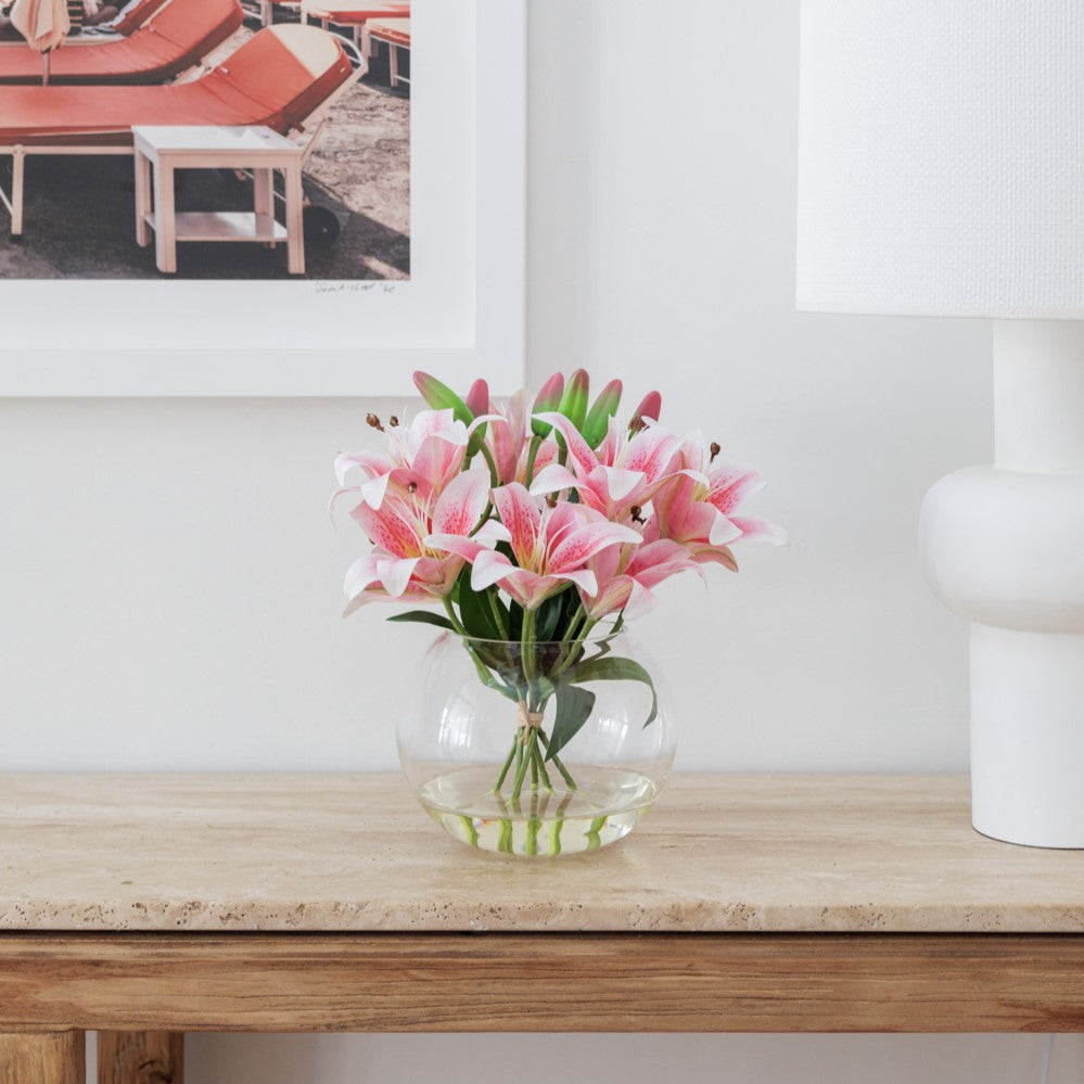 Fake pink lily arrangement being displayed in a hallway