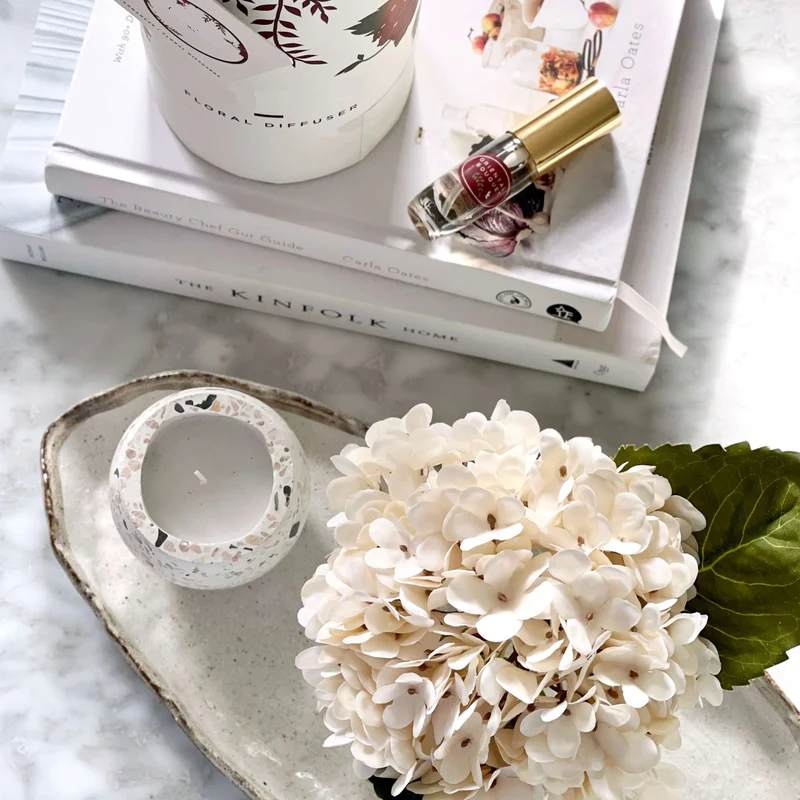 An artificial cream hydrangea flower arrangement paired with a floral scent spray