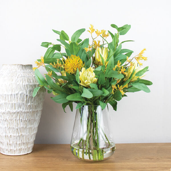 silk flower arrangement set in glass vase using kangaroo paw flowers