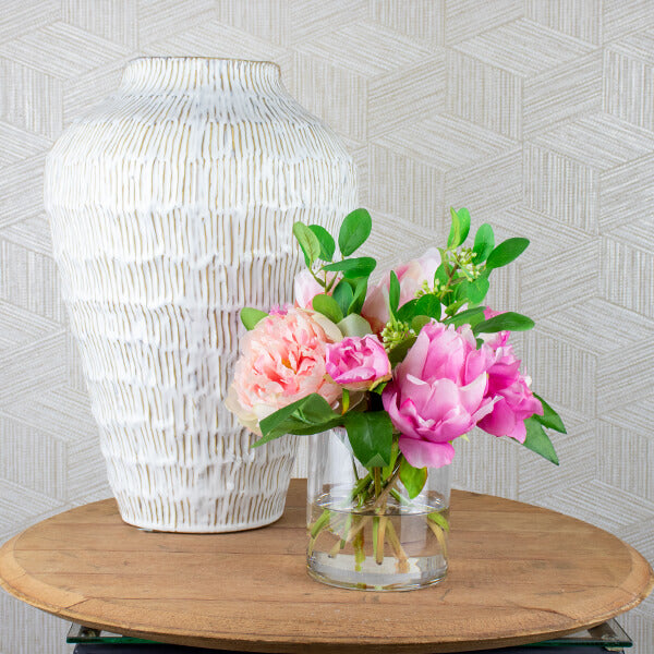 silk peony flower arrangement positioned on a side table