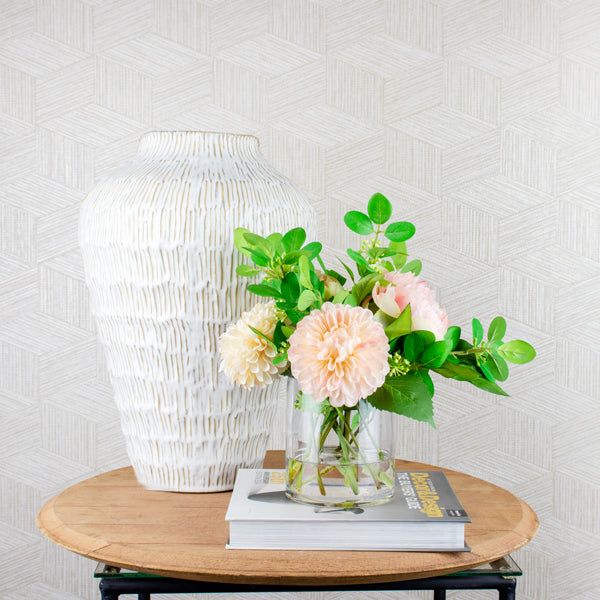 fake peony flowers set in glass vase on a side table