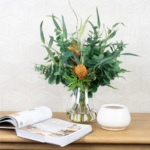 Artificial silk flowers in glass vase