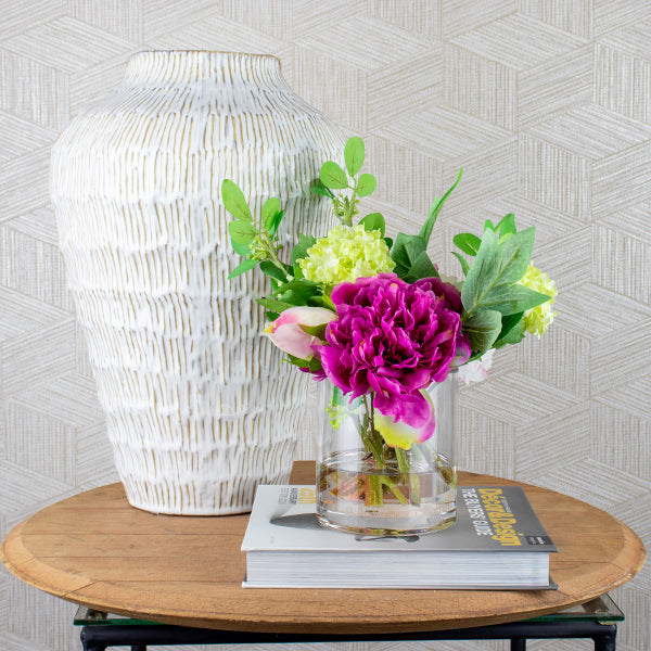 pink silk flower arrangement with peony flowers positioned on a side table