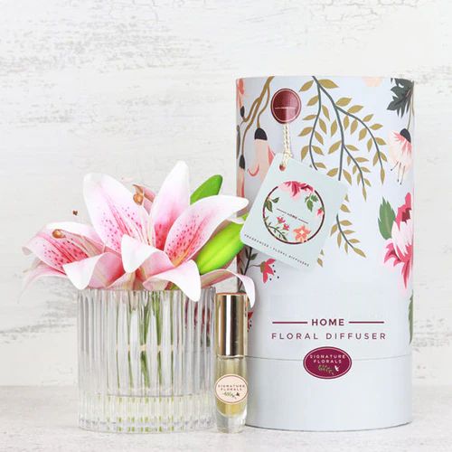 Fake pink lily flowers in vase with perfume spray