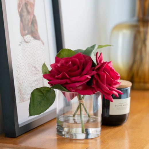 fake red roses in glass vase