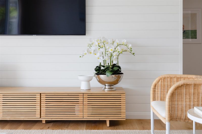 Artificial white orchid plant set in large silver pot