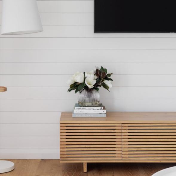 Fake magnolia arrangement sitting on a tv unit for decorative purposes