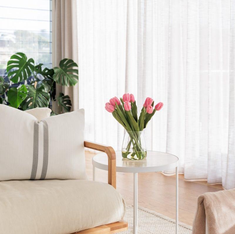 Fake pink tulip arrangement positioned on a side table in the lounge room of an Australian home